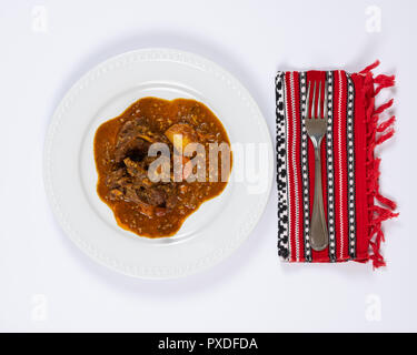 Close-up Platte von bunten Ziege Eintopf mit Kartoffeln, Karotten, Zwiebeln, Lorbeerblatt, und andere Gewürze. Stockfoto