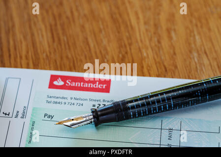 Santander prüfen Buch und Füllfederhalter. Retro oder alte Schule Banking. Schreiben eines prüfen. Stockfoto