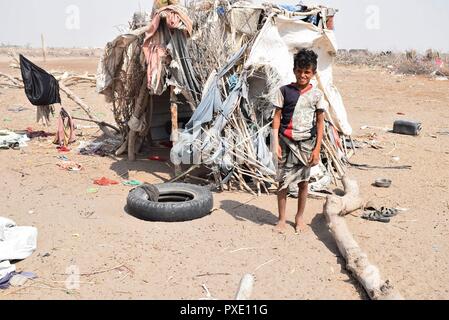 Aden, Jemen. Okt, 2018 21. Eine vertriebene Boy steht neben der Hütte seiner Familie am Stadtrand von Aden, Jemen, Okt. 21, 2018. Tausende von gewaltsam Vertriebenen jemeniten begonnen, sich für den Winter vorbereiten in Hütten und Zelten unter schwierigen Lebensbedingungen sowie Mangel an humanitärer Hilfe in der vom Krieg zerrütteten arabischen Land. Credit: Murad Abdu/Xinhua/Alamy leben Nachrichten Stockfoto