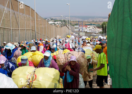 Ceuta, Melilla, Spanien. 13 Aug, 2018. Marokkanische Maultier Frauen gesehen, die Waren an der Grenze zu Melilla nach Spanien. Der spanischen Enklave Melilla Stadt an der nordafrikanischen Küste sitzt, von allen Seiten von Marokko und das Mittelmeer umgeben. Die Stadt wird von einer 20 m hohen Metallzaun heraus zu halten Migranten auf der Suche nach Europa zu kommen, umgeben, aber viele Migranten machen es auf jeden Fall. Die Grenze ist aber auch eine blühende wirtschaftliche Drehscheibe, wo marokkanische Arbeiter waren aus Spanien in Marokko. Credit: SOPA Images/ZUMA Draht/Alamy leben Nachrichten Stockfoto