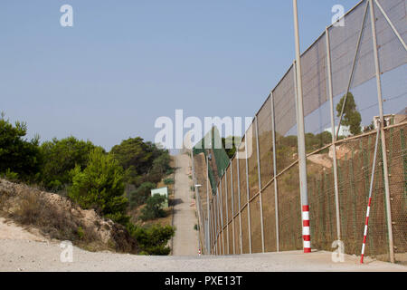 Ceuta, Melilla, Spanien. 13 Aug, 2018. Eine stark befestigte Grenzzaun läuft ca. 11 km von Melilla, Spanien und Marokko. Die Spanische Enklave Stadt Melilla liegt an der nordafrikanischen Küste, von allen Seiten von Marokko und das Mittelmeer umgeben. Die Stadt wird von einer 20 m hohen Metallzaun heraus zu halten Migranten auf der Suche nach Europa zu kommen, umgeben, aber viele Migranten machen es auf jeden Fall. Die Grenze ist aber auch eine blühende wirtschaftliche Drehscheibe, wo marokkanische Arbeiter waren aus Spanien in Marokko. Credit: SOPA Images/ZUMA Draht/Alamy leben Nachrichten Stockfoto