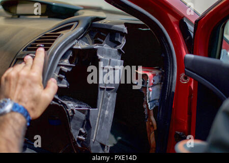 Ceuta, Melilla, Spanien. 13 Aug, 2018. Ein Mitglied der spanischen Guardia Civil gesehen Peeling ein Teil eines Armaturenbrett des Fahrzeugs ein verstecktes Fach, in denen Migranten ausblenden an der Grenze zu Marokko zu schleichen zu offenbaren. Die Spanische Enklave Stadt Melilla liegt an der nordafrikanischen Küste, von allen Seiten von Marokko und das Mittelmeer umgeben. Die Stadt wird von einer 20 m hohen Metallzaun heraus zu halten Migranten auf der Suche nach Europa zu kommen, umgeben, aber viele Migranten machen es auf jeden Fall. Die Grenze ist aber auch eine blühende wirtschaftliche Drehscheibe, wo marokkanische Arbeiter waren aus Spanien in Marokko. (Credi Stockfoto