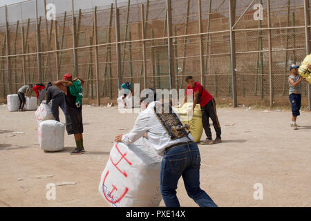 Ceuta, Melilla, Spanien. 13 Aug, 2018. Marokkanische Arbeiter sind sehen Sie 50 kg Pakete von Waren an der Grenze zu Spanien in Marokko. Die spanische Exklave Melilla Stadt an der nordafrikanischen Küste sitzt, von allen Seiten von Marokko und das Mittelmeer umgeben. Die Stadt wird von einer 20 m hohen Metallzaun heraus zu halten Migranten auf der Suche nach Europa zu kommen, umgeben, aber viele Migranten machen es auf jeden Fall. Die Grenze ist aber auch eine blühende wirtschaftliche Drehscheibe, wo marokkanische Arbeiter waren aus Spanien in Marokko. Credit: Julian Hattem/SOPA Images/ZUMA Draht/Alamy leben Nachrichten Stockfoto