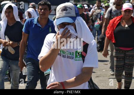 Ciudad Hidalgo, Mexiko. Okt, 2018 21. Zentralamerikanischen Migranten marschieren in der Hitze in die Vereinigten Staaten. Die Migranten aus Honduras, El Salvador und Guatemala haben den Grenzzaun zwischen Guatemala und Mexiko gekreuzt, um von dort an die US-Grenze zu marschieren. Inoffiziellen Schätzungen zufolge gibt es rund 4000 Menschen. Sie werden von der mexikanischen Polizei eskortiert. Credit: Iván Sánchez/dpa/Alamy leben Nachrichten Stockfoto