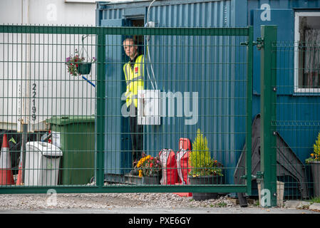 Ein Mitglied von Sicherheit gesehen peeking aus seiner Hütte während seiner Schicht. Die Demonstranten aus dem Vereinigten Königreich stiegen auf das kleine Dorf wenig Plumpton gegen die jüngste Entscheidung für den Frack Cuadrilla Website in Preston neue Strasse wieder aufzunehmen, zu protestieren. Die umstrittene Website wurde mit scharfen Zähnen und Mißbilligung von Anwohnern, die in höheren Plätzen der Regierung getroffen. Stockfoto