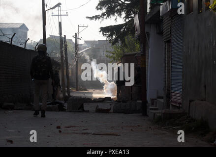 Srinagar, Kashmir. 22. Okt 2018. . Kaschmirischen muslimische Demonstranten Steine werfen an der indischen Polizei soll Gas Shell platzt auf der Straße reißen, während des Protestes. Die gemeinsamen Widerstand Führung (JRL), einer separatistischen Konglomerat unter der Leitung von Syed Ali Geelani, Umer Mirwaiz Farooq und Muhammad Yasin Malik, genannt die Abschaltung gegen sieben Personen in Explosion getötet wurden, nachdem eine Begegnung im Stadtteil Kulgam gestern. Über 40 wurden bei der Explosion und den Unruhen, die folgten, verletzt. © sofi Suhail/Alamy leben Nachrichten Stockfoto