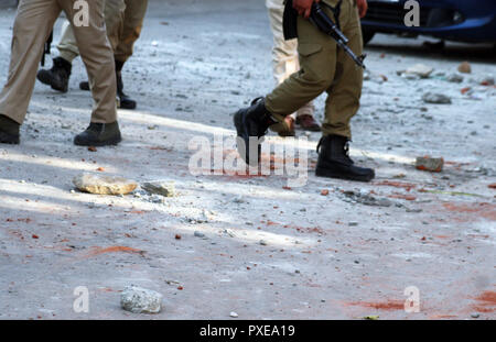 Srinagar, Kashmir. 22. Okt 2018. . Indische Polizei Spaziergänge bei Straßen mit Steinen übersät, während des Protestes. Die gemeinsamen Widerstand Führung (JRL), einer separatistischen Konglomerat unter der Leitung von Syed Ali Geelani, Umer Mirwaiz Farooq und Muhammad Yasin Malik, genannt die Abschaltung gegen sieben Leute waren in Explosion nach eine Begegnung im Stadtteil Kulgam gestern getötet. Über 40 wurden bei der Explosion und den Unruhen, die folgten, verletzt. © sofi Suhail/Alamy leben Nachrichten Stockfoto