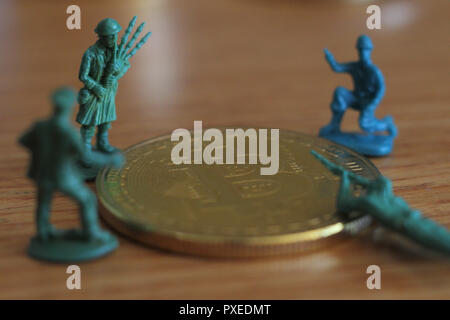 Bitcoin unter Angriff vier Miniatur Männer umgeben von Haufen bitcoin. Miniatur Figur Spielzeug in der Nähe von bitcoin Stockfoto