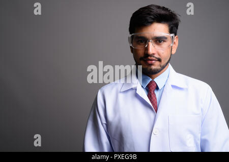 Die Jungen gut aussehenden bärtigen Persischen mann Arzt durch das Tragen von schützender gla Stockfoto