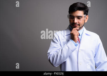 Die Jungen gut aussehenden bärtigen Persischen mann Arzt durch das Tragen von schützender gla Stockfoto