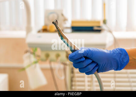 Hand der Zahnarzt in den Handschuh hält zahnmedizinische Bohrmaschine Stockfoto