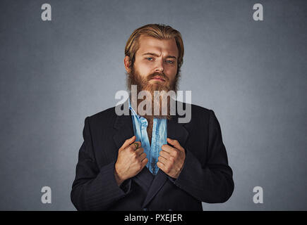 Zuversichtlich bärtigen hipster Geschäftsmann stand gerade an Sie mit seinen Armen, schwarzen Anzug Jacke isoliert auf Grau Grau studio Wand Hinterg Stockfoto