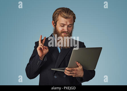 Young Business Mann, der an einem Notebook arbeitet, Frieden Sieg Geste Spaß und Glücklich, positiv und natürliches Konzept Bärtigen hipster Geschäftsmann Isola Stockfoto