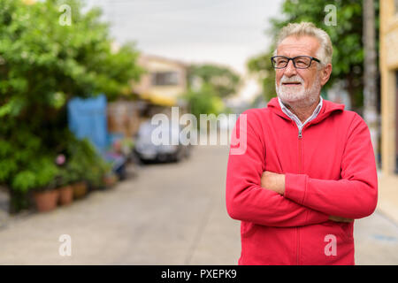 Glücklich aussehenden älteren bärtigen Mann lächelnd und denken beim Wea Stockfoto