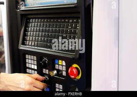 Betreiber arbeiten mit CNC-Drehmaschine über das Bedienfeld Maschine. Selektive konzentrieren. Stockfoto