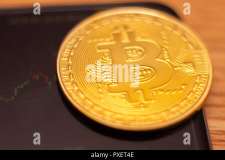 Eine goldene Bitcoin auf Graphen und Diagramme Hintergrund. Konzept der Handel crypto Währung Stockfoto