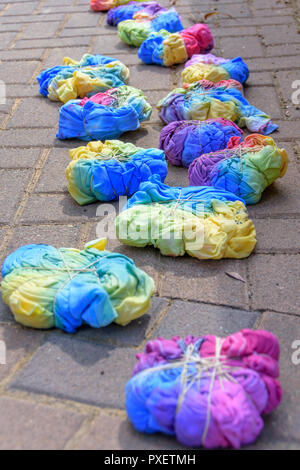 Noch nass Tie-dye T-Shirts mit Gummibändern komprimierte nach von einer Gruppe von Jugendlichen in einem Riegel zu Deckenden-dye Partei Stockfoto