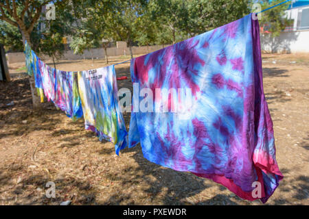 Noch nass Tie-dye T-Shirts hängen auf einem Tuch nach, die von einer Gruppe von Jugendlichen in einem Riegel zu Deckenden-dye Partei Stockfoto