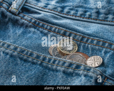 Neue Pound Münze und andere kleine Änderung in Jeans Tasche rutscht. Metapher UK Löhne. Stockfoto