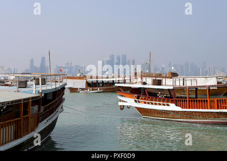 Doha/Katar - Oktober 10, 2018: traditionelle Dhows bis günstig entlang der Corniche in der katarischen Hauptstadt Doha, mit den Wolkenkratzern der West Bay Area Stockfoto