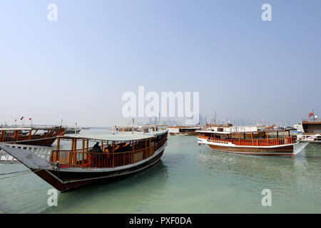 Doha/Katar - Oktober 10, 2018: traditionelle Dhows bis günstig entlang der Corniche in der katarischen Hauptstadt Doha, mit den Wolkenkratzern der West Bay Area Stockfoto