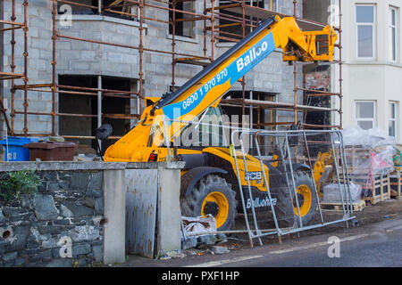 11. Oktober 2018 Eine große Teleskoplader in der Bauwirtschaft auf einer kleinen Baustelle auf einer Meeresklippe Straße in Bangor County D geparkt Stockfoto