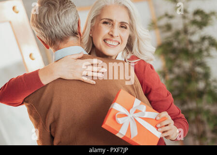 Ältere Frauen, die Glückwünsche von ihrem Mann begeistert. Stockfoto