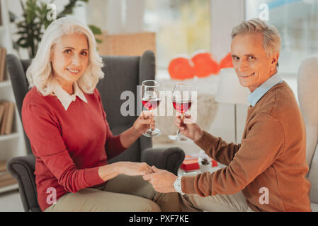 Gerne älteres Paar mit Brille halten jedes andere Hände Stockfoto