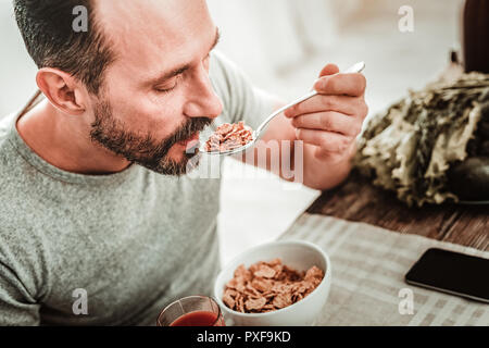 Angenehm nett aussehenden Mann mit einem Löffel Stockfoto