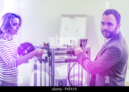 Der bärtige Mann seine Frau mit 3D Drucker beim Familienunternehmen Stockfoto