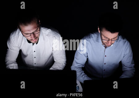 Bis zu schließen. zwei Kollegen arbeiten an Computern Stockfoto