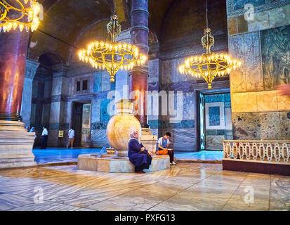 Zwei Touristen, einem arabischen und einem Asiatischen, Ruhe vor einem der Marmor Gläser im Langhaus der Hagia Sophia. Istanbul, Türkei. Stockfoto