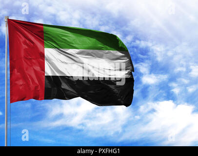 Die Flagge der Vereinigten Arabischen Emirate auf einem Fahnenmast vor blauem Himmel. Stockfoto