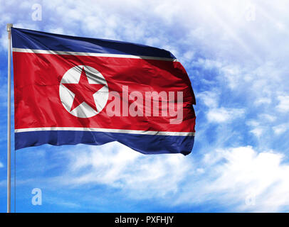 Nationalflagge von Nordkorea auf einem Fahnenmast vor blauem Himmel. Stockfoto