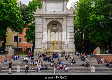 Junge Menschen auf den Stufen an der Piazza Trilussa, Trastevere, Rom sitzen Stockfoto