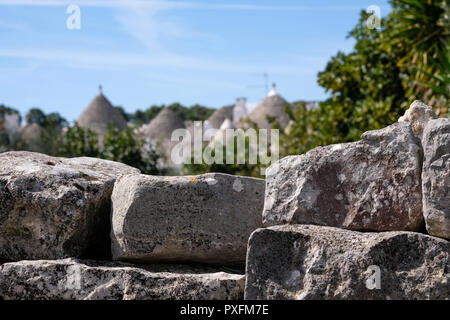 In bakcground, traditionellen weiß-Konische gewaschen - überdachte Trulli in Alberobello, Apulien, Süditalien. Trockenmauer im Fokus Stockfoto