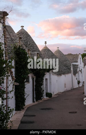 Ansicht der traditionellen weißen Trockenmauern Trulli auf einer Straße im Stadtteil Monti Bereich von Alberobello in Apulien, Italien. Stockfoto