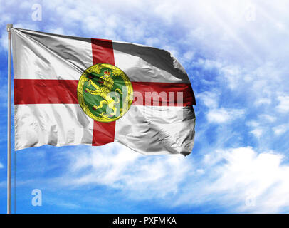 Nationalflagge von Alderney an einem Fahnenmast vor blauem Himmel. Stockfoto