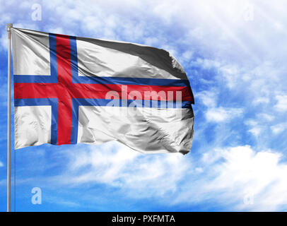 Die Flagge der Färöer Inseln auf einem Fahnenmast vor blauem Himmel. Stockfoto