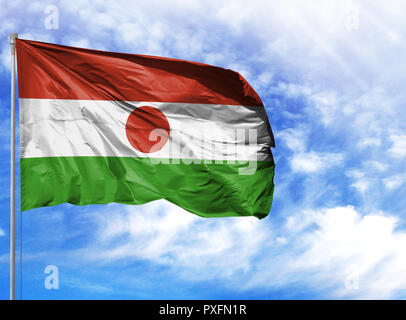 Nationalflagge von Niger an einem Fahnenmast vor blauem Himmel. Stockfoto