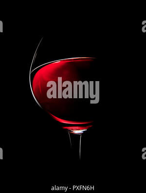 Ein Glas Rotwein fotografiert mit rim Licht auf schwarzem Hintergrund (Fokus auf Flanke von Glas) Stockfoto