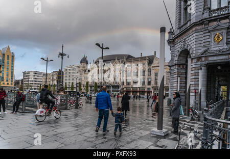 Antwerpen, Belgien - 2018-10-01: Menschen zu Fuß & Regenbogen über dem Koningin Astridplein (Königin Astrid Square), aus der Ecke mit dem Keijserlei gesehen. Stockfoto