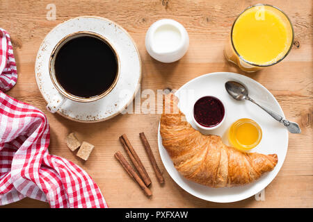 Frühstück mit Croissant, Kaffee, Orangensaft und Marmelade. Rustikale Holz Tisch Hintergrund, Ansicht von oben Stockfoto