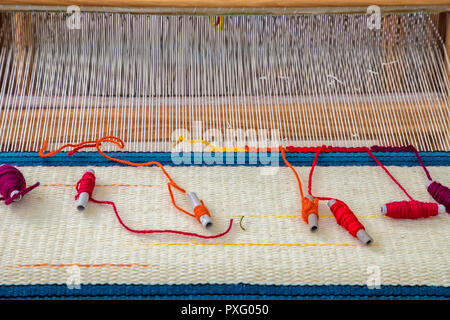 Eine traditionelle bunte vintage Webstuhl und Gewinde von Garn. Stockfoto