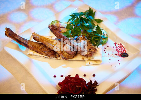 Gebackene Lamm Rippen mit Gemüse auf einem weißen Teller. Stockfoto