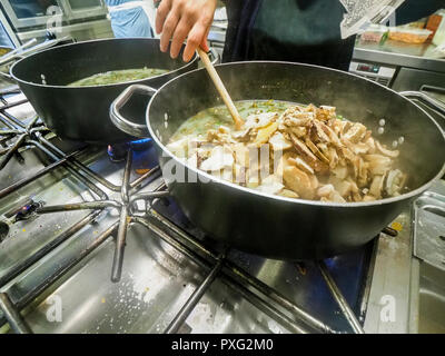Italienischen Chefkoch Zubereitung risotto klassische italienische Reisgericht mit asparagi und Pilze Stockfoto