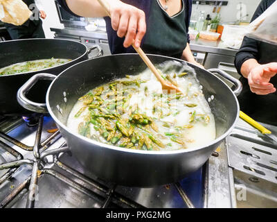 Italienischen Chefkoch Zubereitung risotto klassische italienische Reisgericht mit asparagi und Pilze Stockfoto