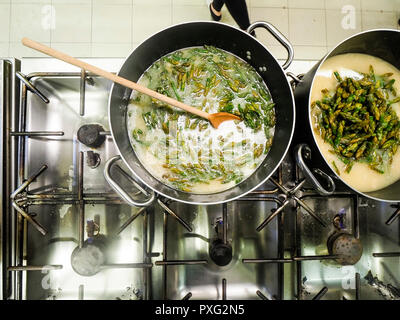 Italienischen Chefkoch Zubereitung risotto klassische italienische Reisgericht mit asparagi und Pilze Stockfoto