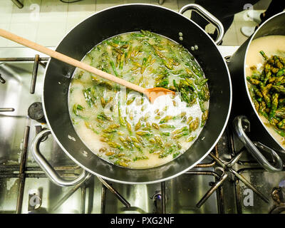 Italienischen Chefkoch Zubereitung risotto klassische italienische Reisgericht mit asparagi und Pilze Stockfoto