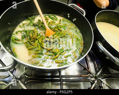 Italienischen Chefkoch Zubereitung risotto klassische italienische Reisgericht mit asparagi und Pilze Stockfoto